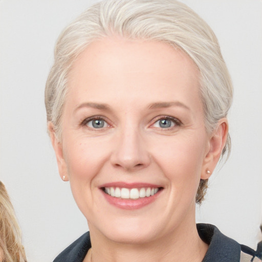 Joyful white adult female with medium  blond hair and blue eyes