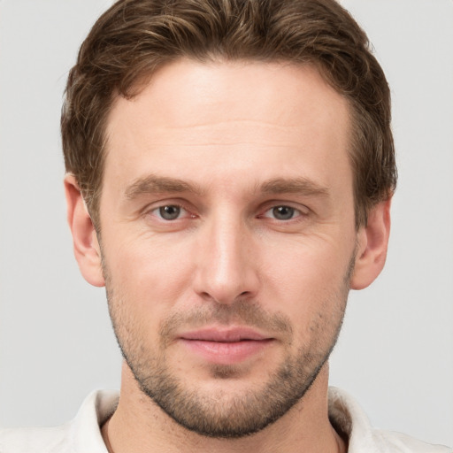 Joyful white young-adult male with short  brown hair and grey eyes