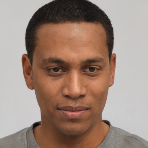 Joyful black young-adult male with short  black hair and brown eyes