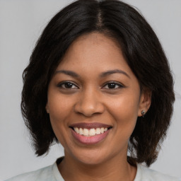 Joyful black young-adult female with medium  brown hair and brown eyes