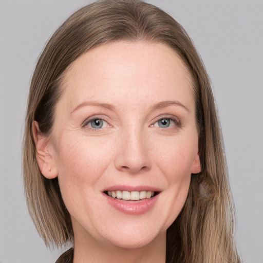 Joyful white adult female with long  brown hair and grey eyes