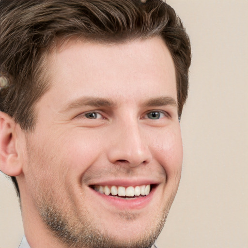 Joyful white young-adult male with short  brown hair and grey eyes