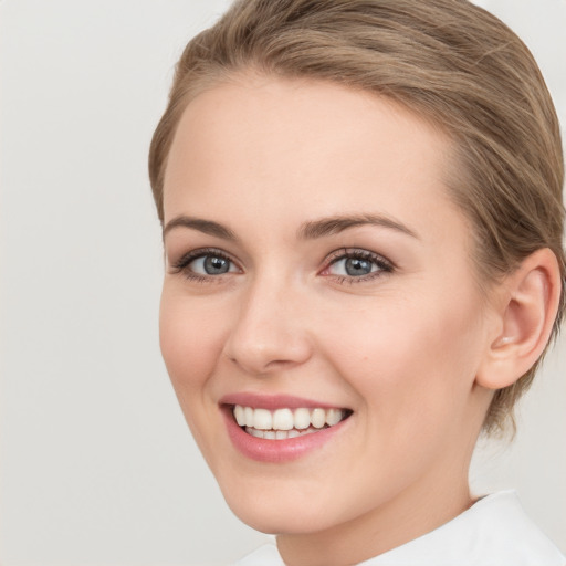 Joyful white young-adult female with medium  brown hair and green eyes