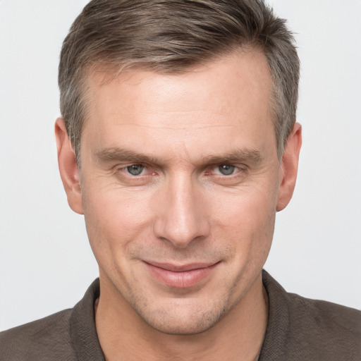 Joyful white adult male with short  brown hair and grey eyes