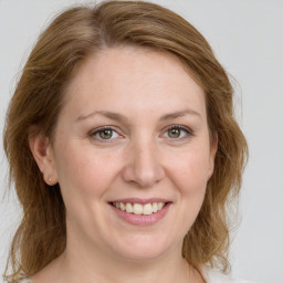 Joyful white adult female with medium  brown hair and green eyes