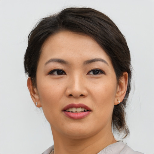 Joyful asian young-adult female with medium  brown hair and brown eyes