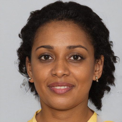 Joyful black young-adult female with medium  brown hair and brown eyes