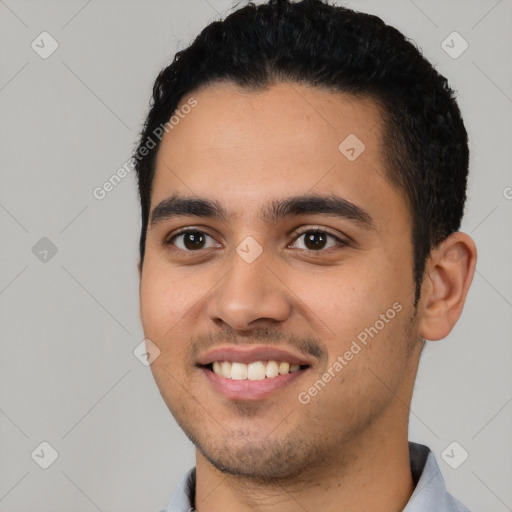 Joyful latino young-adult male with short  black hair and brown eyes