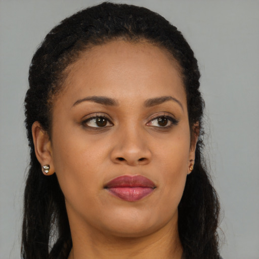Joyful black young-adult female with long  brown hair and brown eyes