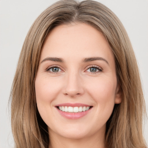 Joyful white young-adult female with long  brown hair and green eyes