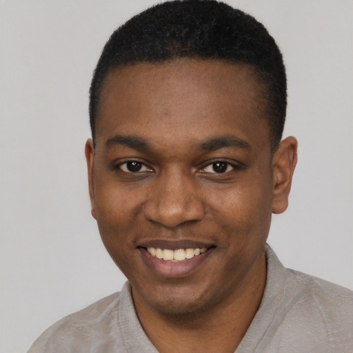 Joyful black young-adult male with short  black hair and brown eyes