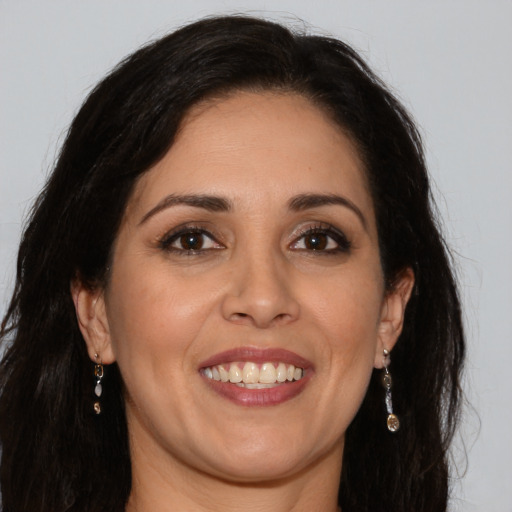 Joyful white adult female with long  brown hair and brown eyes