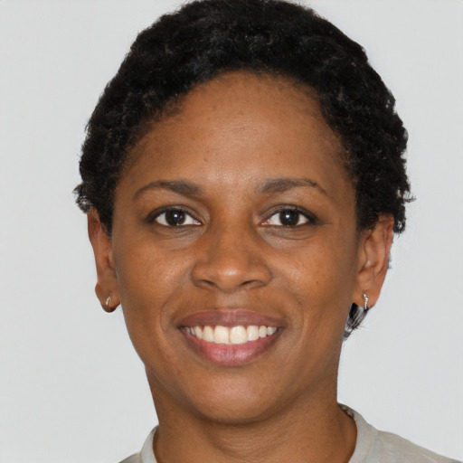Joyful black young-adult female with short  brown hair and brown eyes