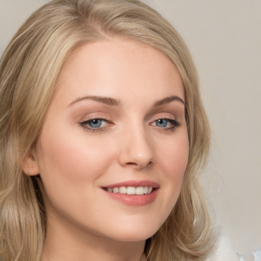 Joyful white young-adult female with long  brown hair and blue eyes