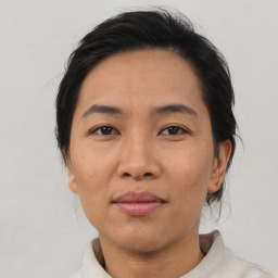 Joyful asian adult female with medium  brown hair and brown eyes