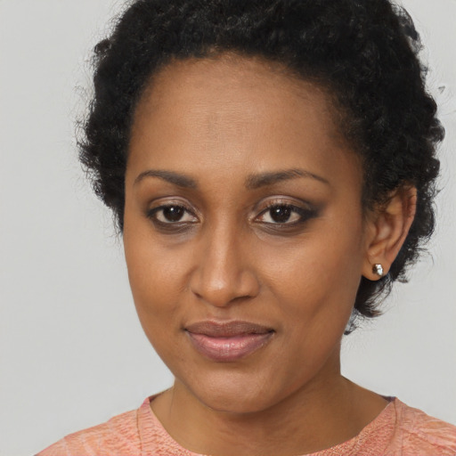 Joyful black young-adult female with short  brown hair and brown eyes