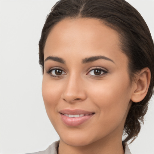 Joyful latino young-adult female with long  brown hair and brown eyes