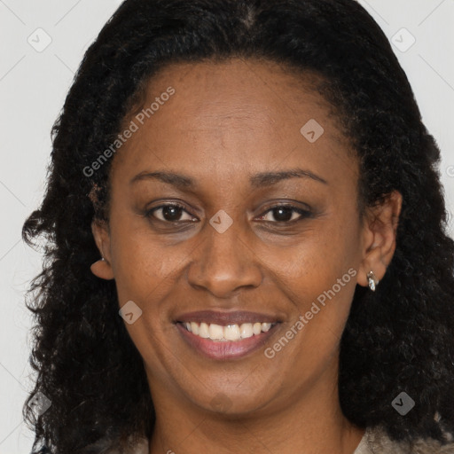 Joyful black adult female with long  brown hair and brown eyes