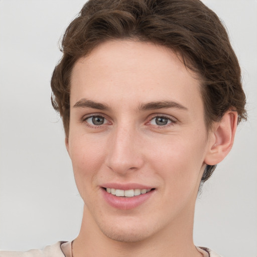 Joyful white young-adult female with short  brown hair and grey eyes