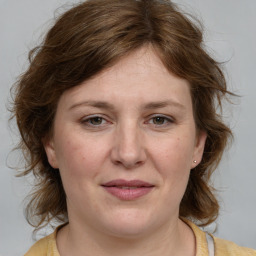 Joyful white young-adult female with medium  brown hair and blue eyes