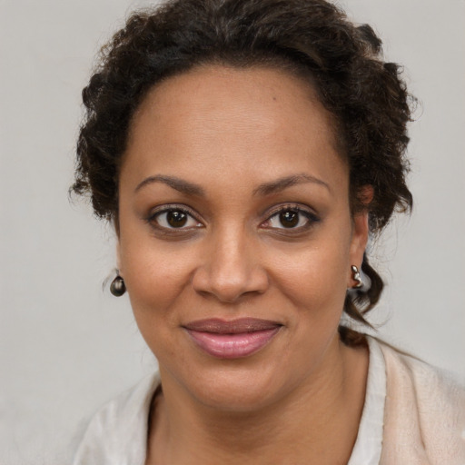 Joyful black adult female with short  brown hair and brown eyes