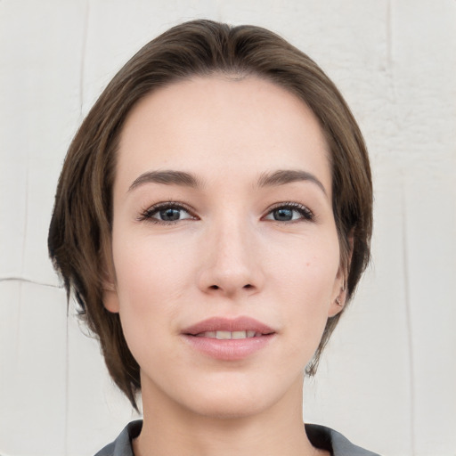 Joyful white young-adult female with medium  brown hair and grey eyes