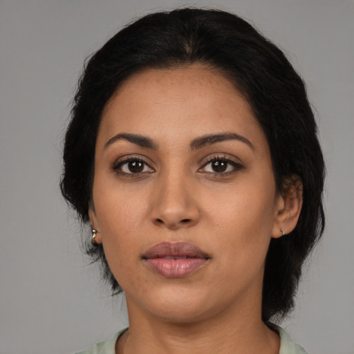 Joyful latino adult female with medium  black hair and brown eyes