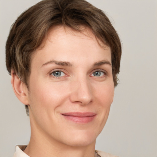 Joyful white young-adult female with short  brown hair and grey eyes