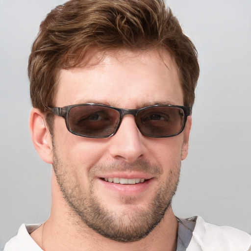 Joyful white young-adult male with short  brown hair and grey eyes