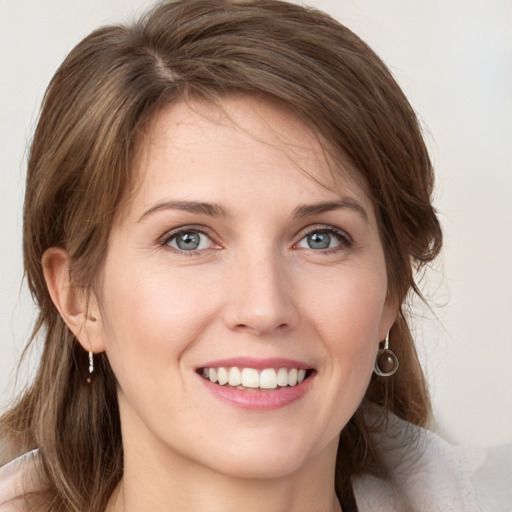 Joyful white young-adult female with medium  brown hair and green eyes