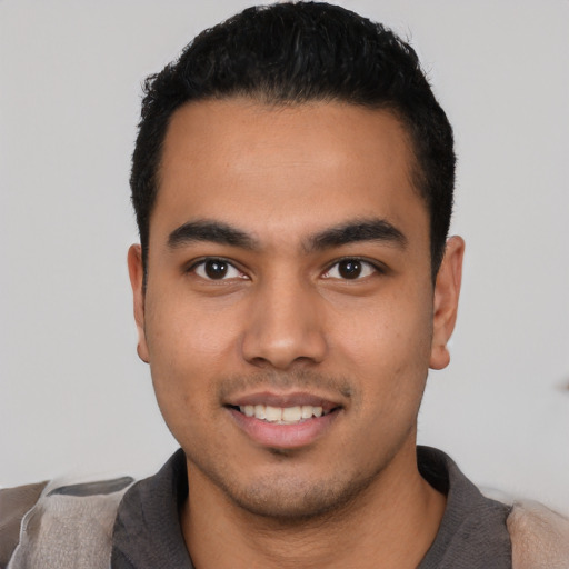 Joyful latino young-adult male with short  black hair and brown eyes