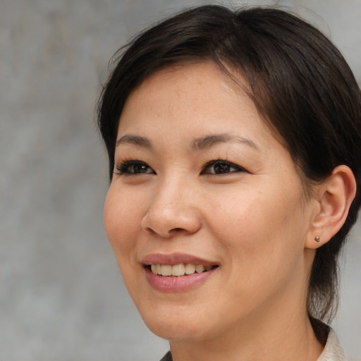 Joyful asian young-adult female with medium  brown hair and brown eyes