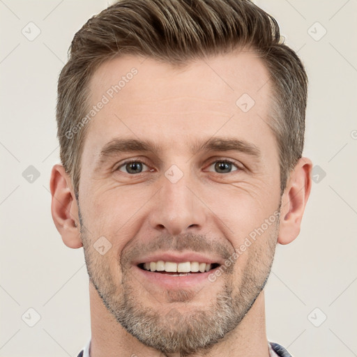 Joyful white young-adult male with short  brown hair and grey eyes