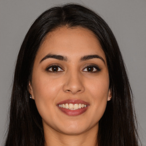 Joyful latino young-adult female with long  brown hair and brown eyes