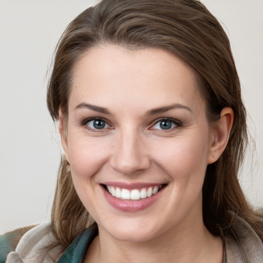 Joyful white young-adult female with medium  brown hair and grey eyes