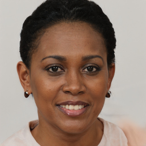Joyful black young-adult female with short  brown hair and brown eyes