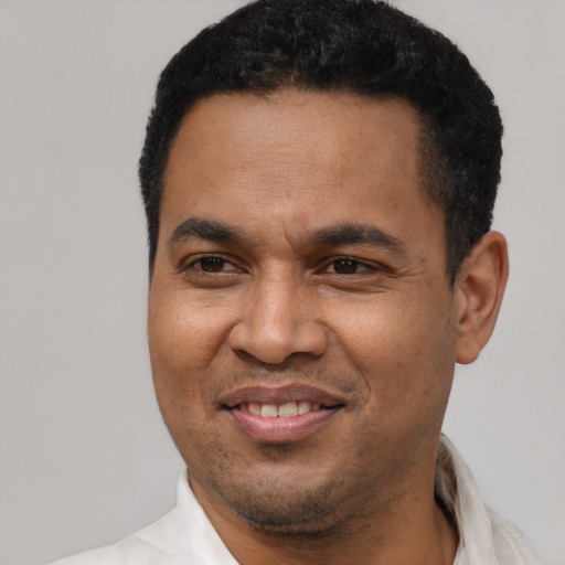 Joyful latino adult male with short  black hair and brown eyes