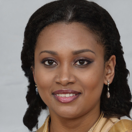 Joyful black young-adult female with long  brown hair and brown eyes