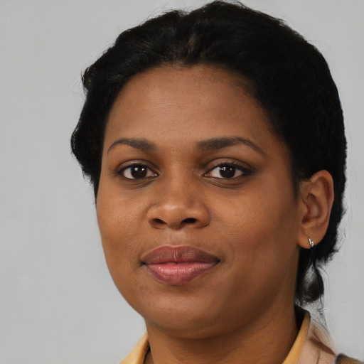 Joyful black young-adult female with short  black hair and brown eyes