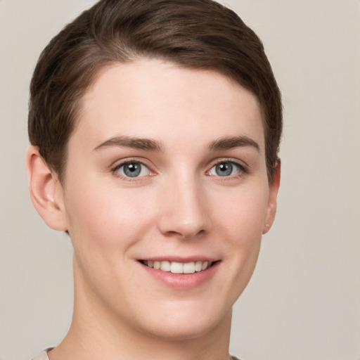 Joyful white young-adult female with short  brown hair and grey eyes