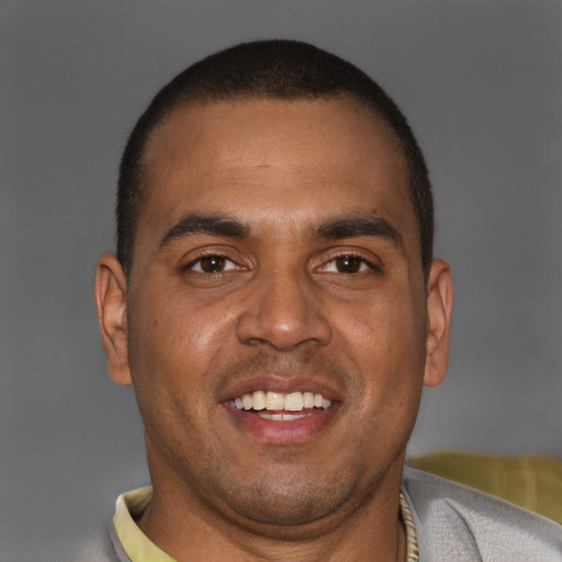 Joyful black adult male with short  brown hair and brown eyes