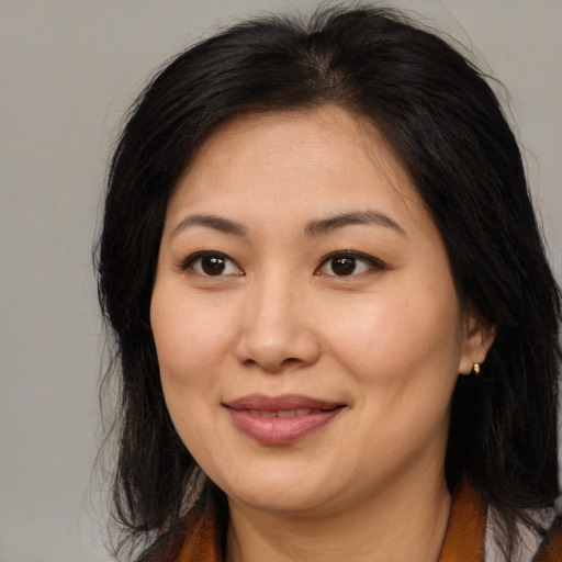 Joyful asian adult female with long  brown hair and brown eyes
