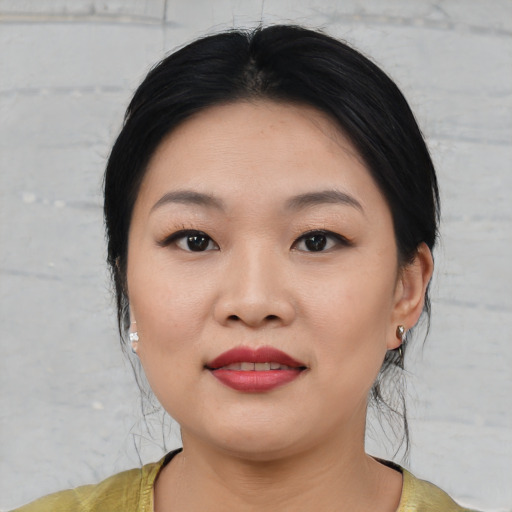 Joyful asian young-adult female with medium  black hair and brown eyes