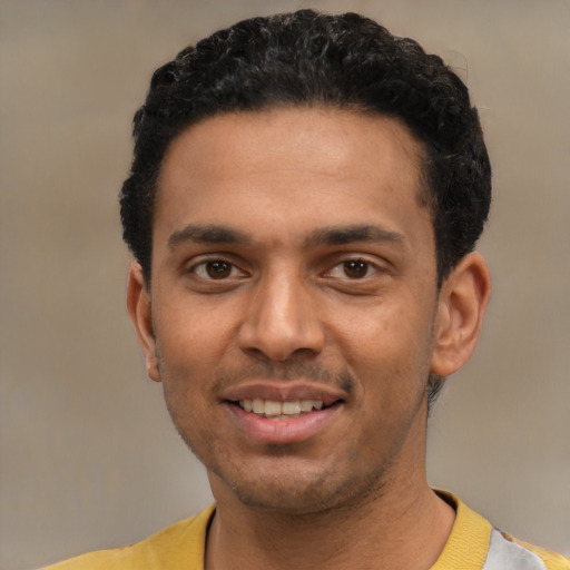 Joyful latino young-adult male with short  black hair and brown eyes