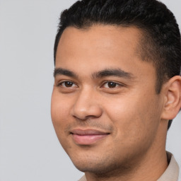 Joyful latino young-adult male with short  brown hair and brown eyes