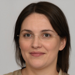 Joyful white adult female with medium  brown hair and brown eyes