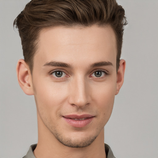 Joyful white young-adult male with short  brown hair and grey eyes