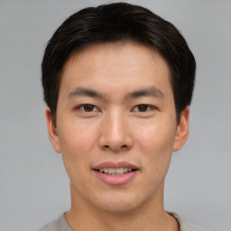 Joyful asian young-adult male with short  brown hair and brown eyes