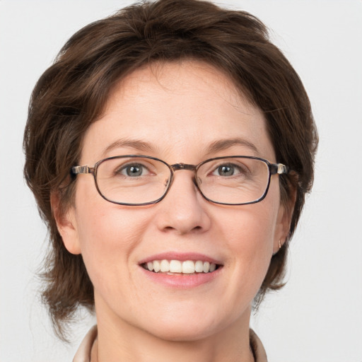 Joyful white adult female with medium  brown hair and blue eyes