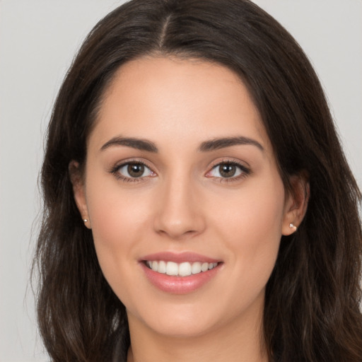 Joyful white young-adult female with long  brown hair and brown eyes